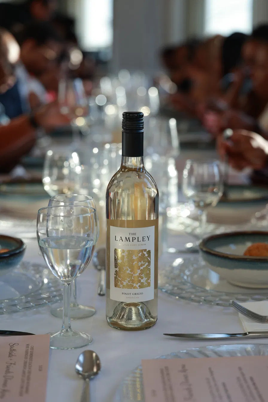 The Lampley Pinot Grigio set on a long dinner table with glasses and guests
